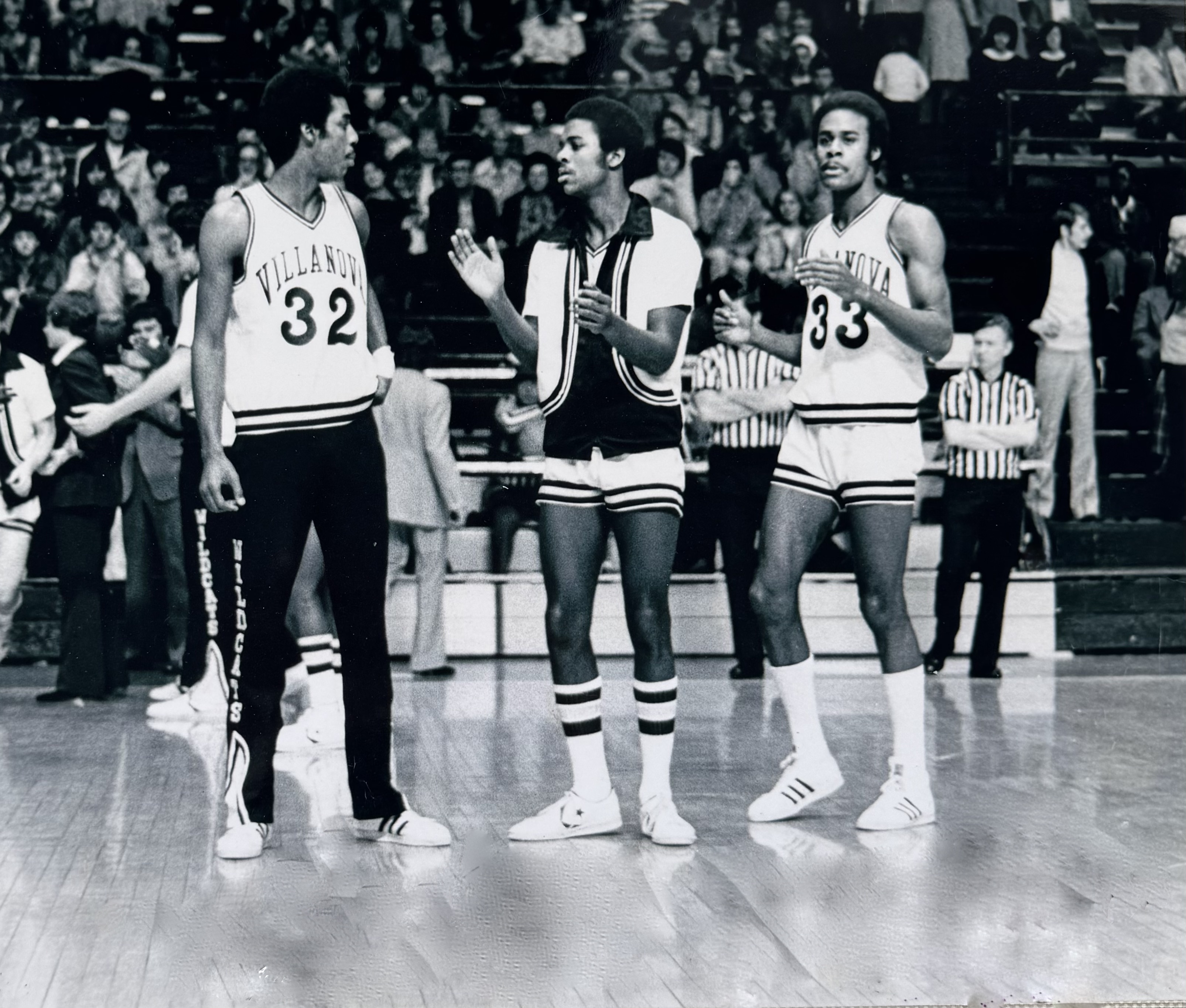 Larry Herron (#32), Reggie Herron in warmups, and Keith Herron (#33) on the court in Villanova uniforms before a packed arena />
      <figcaption><strong>Larry (#32) · Reggie (#45) · Keith (#33)</strong></figcaption>
    </figure>
    <p class=